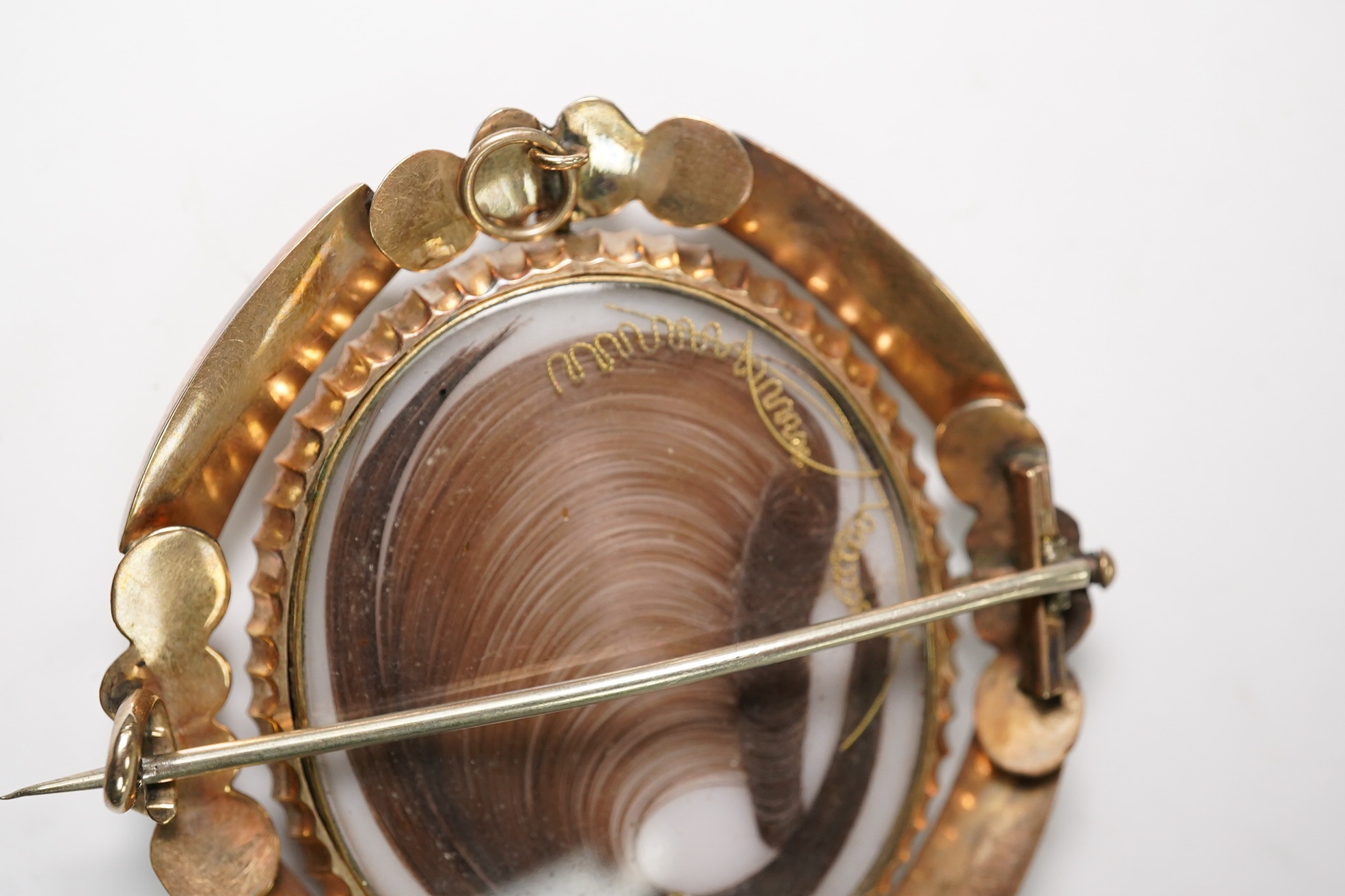 A cased Victorian yellow metal and plaited hair sey oval mourning brooch, 59mm. Condition - fair